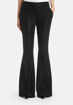 Black flared trousers featuring a textured, sparkly fabric with a fitted waist, front pleats, and side pockets. Snug fit through the hips.