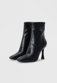 Black leather ankle boots with a pointed toe, zip closure, and a slender high heel. Smooth texture with subtle stitching details.