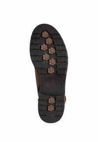 Brown rubber boot sole with a textured black surface, featuring a hexagonal pattern and multiple traction lugs for grip.