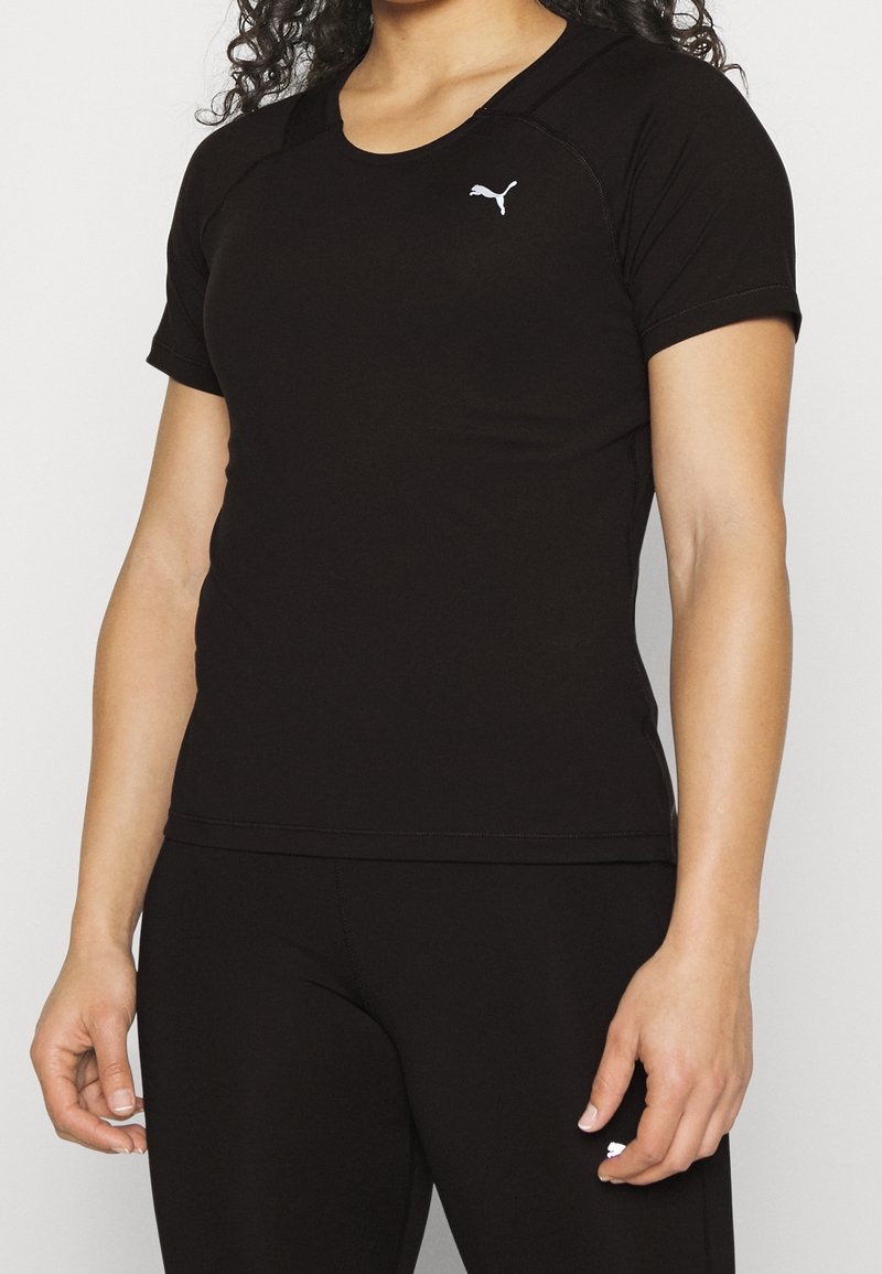 Černé sportovní tričko s krátkým rukávem, kulatým výstřihem a bílým logem Puma na hrudi. Hladká textura, obepnutý střih.