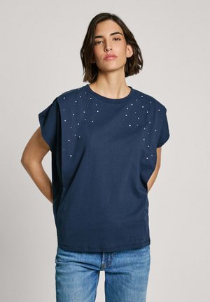 Marineblauwe t-shirt met korte mouwen en decoratieve zilveren studs op de schouders. Gemaakt van zachte stof met een ontspannen pasvorm.