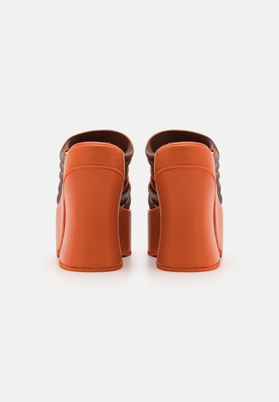 Pantofi cu toc înalt, având o bază din piele portocalie, cu un superior texturat de culoare maronie, finisaj neted și un design cu toc pătrat.