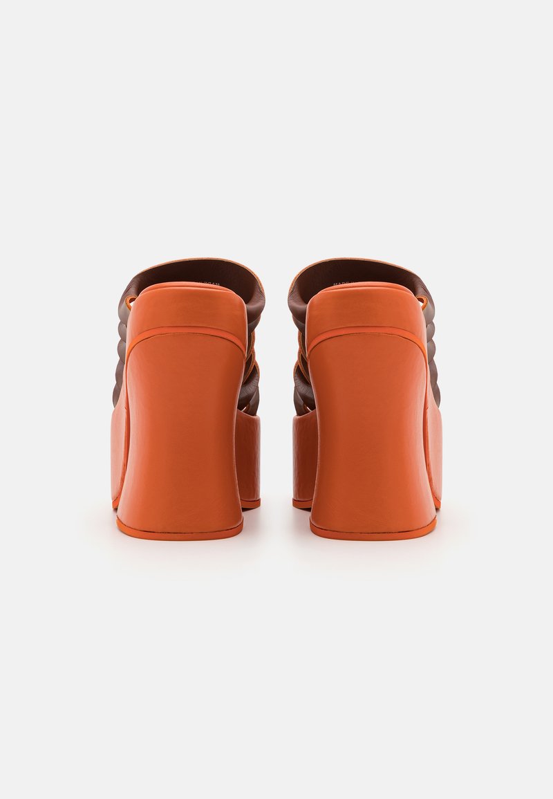 Hoge hakken met een oranje lederen basis en een bruine, textuurrijke bovenkant, met een gladde afwerking en een blockhak ontwerp.