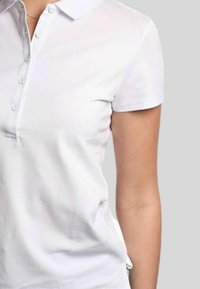 Polo bianco con maniche corte, patta con bottoni e un logo discreto. Tessuto liscio e design del colletto classico.