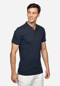 Polo de color azul marino, de manga corta, con cuello plano, tapeta de dos botones, diseño ajustado, elaborado con suave tela de algodón. Textura lisa.