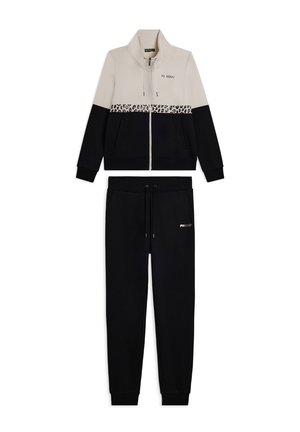 Giacca da track con zip beige e nera con striscia leopardata e pantaloni jogger neri coordinati con tasche e cordino.