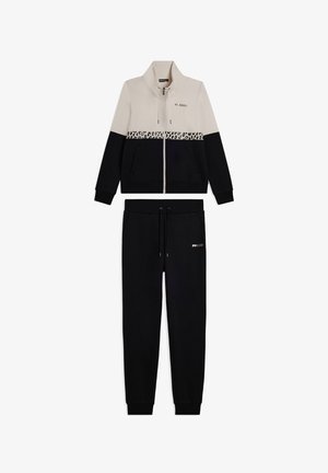 Giacca da track con zip beige e nera con striscia leopardata e pantaloni jogger neri coordinati con tasche e cordino.