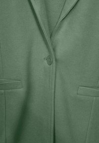 Olivově zelený kardigan se zářezovým límcem, zapínáním na jeden knoflík a dvěma předními kapsami. Měkká pletená textura s hladkým povrchem.