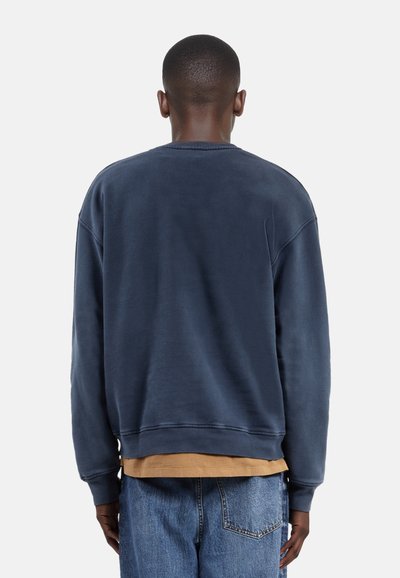 Marineblauwe sweatshirt met een ronde hals, ribgebreide boorden en zoom. Beschikt over een losse pasvorm en een zachte textuur met zichtbare stikdetails.