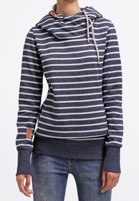 Hoodie s námořnickými pruhy vyrobený z měkké tkaniny, má límec s kapucí, stahovací šňůrku a manžety s otvory pro palec. Obsahuje malou značkovou nášivku na boku.