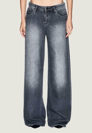 Jean large en denim gris foncé, présentant une texture délavée, cinq poches et une fermeture éclair. Les jambes se resserrent légèrement vers l'ourlet.