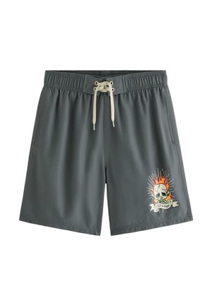 Mørkegrå badeshorts med hvid snøre og flaming kranie-grafik med teksten "Wild & Free" på højre ben.