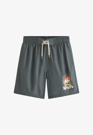Mørkegrå badeshorts med hvid snøre og flaming kranie-grafik med teksten "Wild & Free" på højre ben.