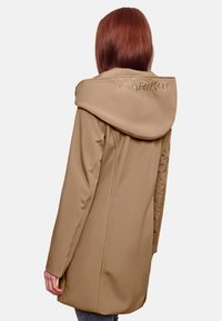 Beige lange jas met een grote capuchon, voorzien van een geborduurde merknaam op de rug, gemaakt van soepel, lichtgewicht materiaal.