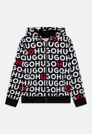 Sweat à capuche noir zippé avec le texte blanc "HUGO" répété et certaines lettres en rouge, avec capuche et poches avant.
