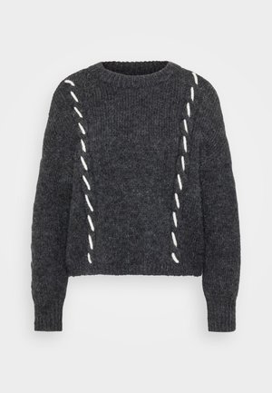 Temno siv volnen pulover s krojem katerega kroj sega do vratu, ohlapnim prilegajočim in belim šivom ob straneh. Struktura pletenine z dolgimi rokavi.