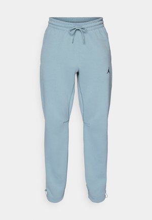 Light blue sweatpants made of soft fabric, featuring an elastic waistband with drawstring, side pockets, and a small black logo on the thigh.