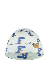 Soft baby hat with blue and orange dinosaur prints and a small brown fabric label on light cream background.