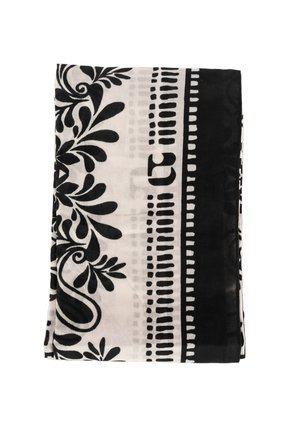 Tela doblada con patrones florales y geométricos en blanco y negro sobre un fondo claro y un borde negro sólido.