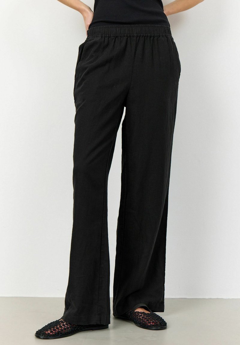 Svarta, löst sittande byxor i lätt tyg med elastisk midja och sidofickor. Rätt fram med vida ben och subtil textur.