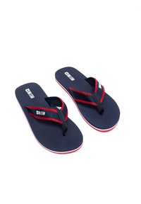 Námořnické žabky s červenými akcenty. Texturované popruhy s logem, plochá stélka, minimalistický design, gumová podrážka s tenkým bílým proužkem.