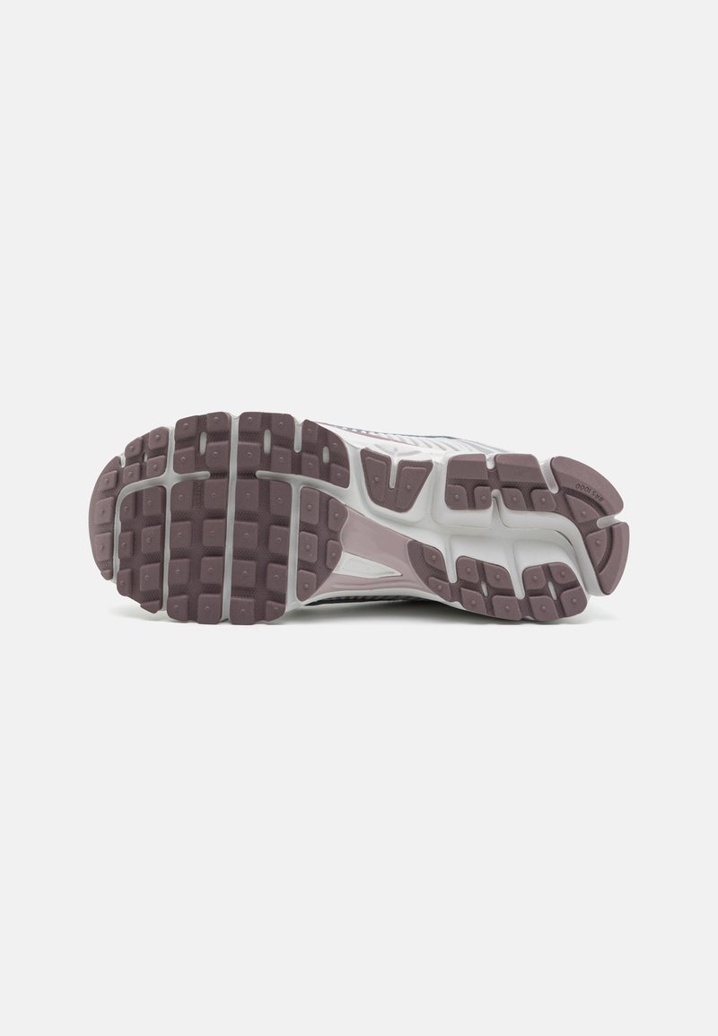 Semelle de chaussure avec un design texturé et à motifs en gris clair, accentué de gris foncé et de lavande. Lugs en caoutchouc distinctifs pour une meilleure traction.