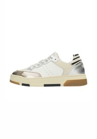 Zapatilla con un cuerpo de piel blanca, acentos metálicos plateados, superposiciones beige y un respaldo con patrón de cebra. Cuenta con una suela de goma y cordones texturizados.