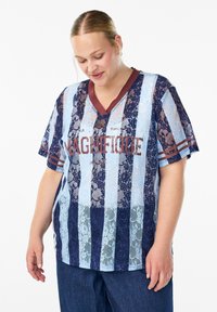 Gestreiftes T-Shirt aus Spitze in Blau und Marine, mit einem V-Ausschnitt, kurzen Ärmeln und einem burgunderfarbenen "MAGNIFIQUE"-Textdetails auf der Vorderseite.