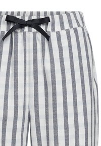 Lettere bomulds pijama bukser med skiftende hvide og marineblå lodrette striber. Elastisk talje med en sort båndsløjfe detalje.