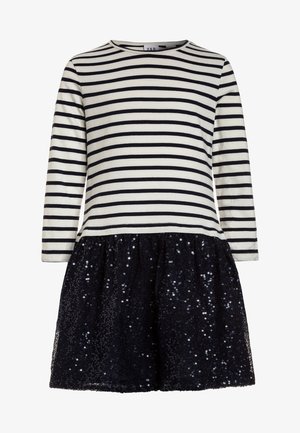 Robe à manches longues avec un haut à rayures horizontales blanches et noires et une jupe en tulle noire à paillettes.