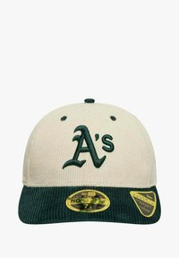 Cappello in velluto a coste crema con visiera verde e logo "A's" ricamato, caratterizzato da una finitura testurizzata e etichette ufficiali New Era.