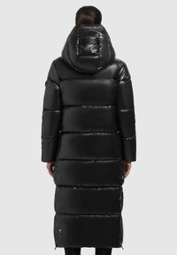 Geacă puffer lungă, de culoare neagră, cu un finisaj lucios, având glugă și un design matlasat orizontal. Include un detaliu cu logo pe spate.