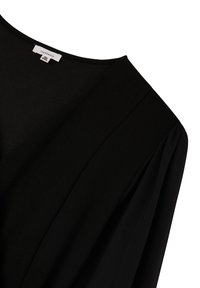 Czarna bluzka o gładkiej fakturze, szerokim dekolcie i zwiewnych rękawach. Posiada metkę z oznaczeniem rozmiaru XXL. Prosty, elegancki design.