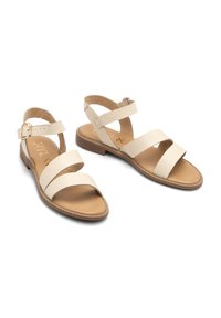 Beżowe skórzane sandały z trzema szerokimi paskami, zapięciem na kostce i niskim słupkowym obcasem; gładka faktura i jasnobrązowa wkładka.
