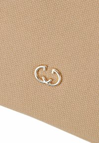 Borsa in tessuto beige con superficie texturizzata e dettaglio del logo interlocking in oro metallico. Design semplice senza ulteriori decorazioni.