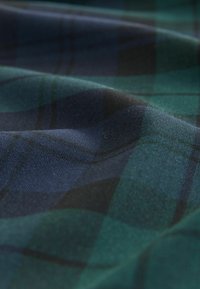 Dunkelkarierter Stoff mit grünen, schwarzen und marineblauen Farben, der eine glatte Textur und einen soften Fall aufweist und ein klassisches Karomuster zeigt.