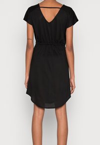 Schwarzes Kleid mit kurzen Ärmeln, V-Ausschnitt hinten, elastischem Taillenbund und abgerundetem Saum. Hergestellt aus weichem, leichtem Material.