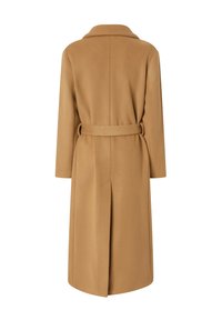 Dugi bež kaput od mekog materijala, s oštrim kragnama, remenom u struku i stražnjim prorezom. Čiste linije i minimalne detalje.