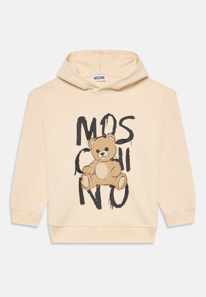 Beżowa bluza z kapturem z grafiką misia i czarnym, kapącym napisem "MOSCHINO" z przodu.