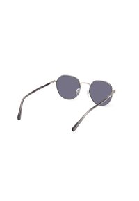 Gafas de sol ovaladas con lentes oscuros, montura metálica plateada y brazos translúcidos grises. Incluyen almohadillas nasales para mayor comodidad.