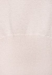 Tessuto lavorato a maglia rosa chiaro con una texture a coste; presenta filamenti sottili e luccicanti intrecciati per un lieve luccichio.