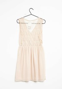 Světle růžové šaty s krajkovým korzetem a rozšířenou sukní. Mají výstřih do V a hladkou, splývavou texturu. Visí na černém háčku.