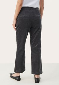 Pantalon en velours côtelé gris avec une coupe droite, tissu texturé, deux poches arrière et une ceinture visible en haut.