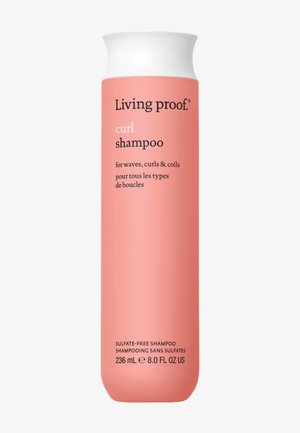 Krullen shampoo in een roze plastic fles met een witte dop, met zwarte tekst die gebruik voor golven en krullen beschrijft. Capaciteit van 236 mL.