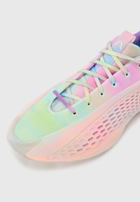 Baskets avec dégradé de couleurs pastel, lacets arc-en-ciel pastel, tige en mesh et semelle sculptée avec découpes hexagonales sur fond blanc.