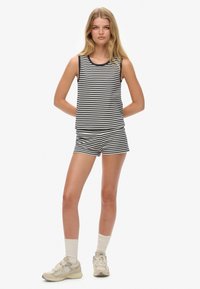 Black and white striped tank top and shorts set, made of lightweight fabric, featuring a racerback design and a relaxed fit.