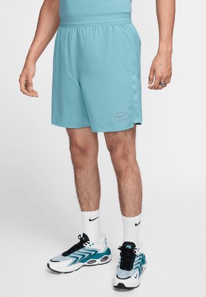Lichtblauwe sportshorts van gladde stof, met een elastische tailleband, een zijzak en het Nike-logo aan de linkerpunt.