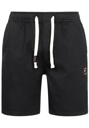 Čierne šortky vyrobené z mäkkej tkaniny, s elastickým pásom a bielymi šnúrkami, bočnými vreckami a malým zlatým logom.