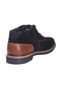 Botine negre din suede până la gleznă cu toc din piele maro, fermoare laterale și cusături contrastante. Talpă din cauciuc și guler căptușit pentru confort.