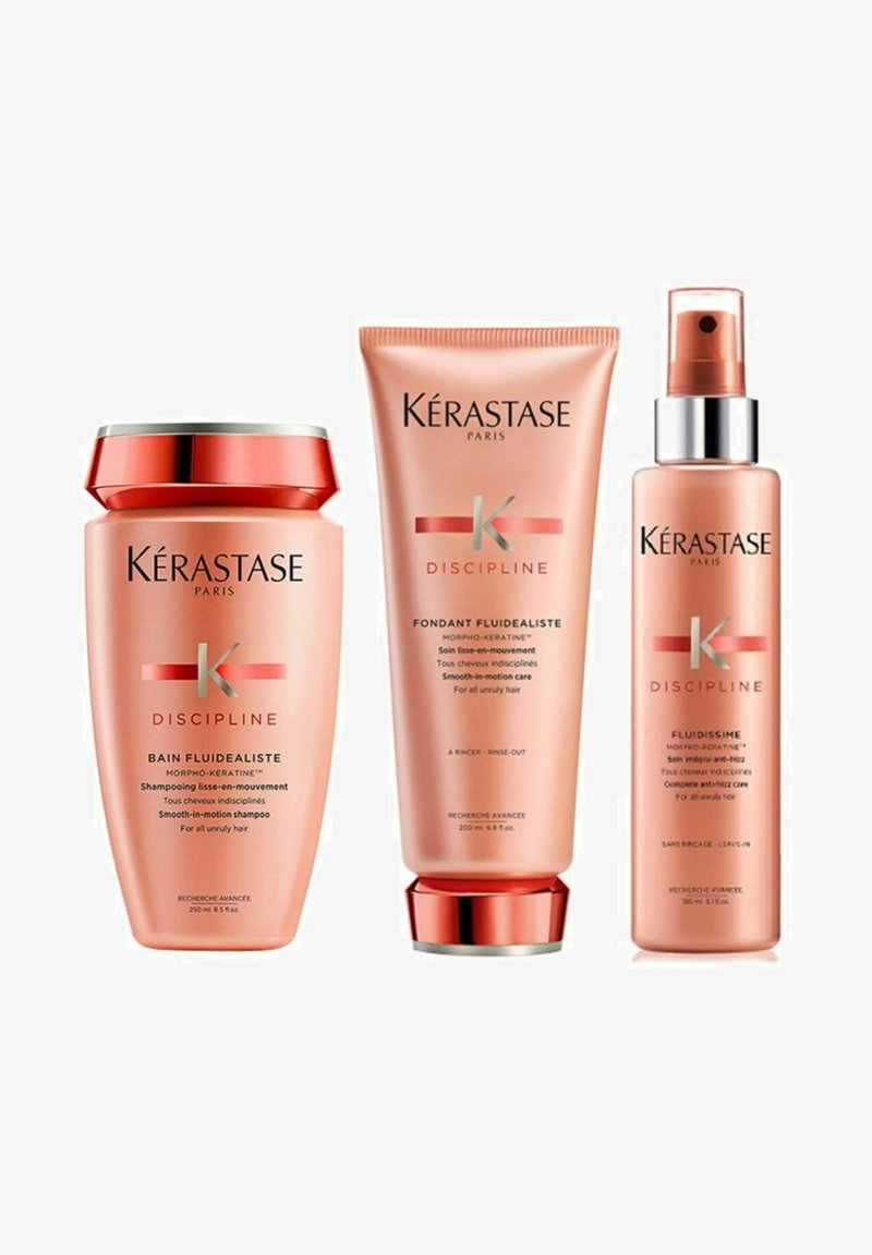 Kérastase Discipline haircare trio includes a pink shampoo jar, conditioner tube, and leave-in fluid. Features silver and gold accents.